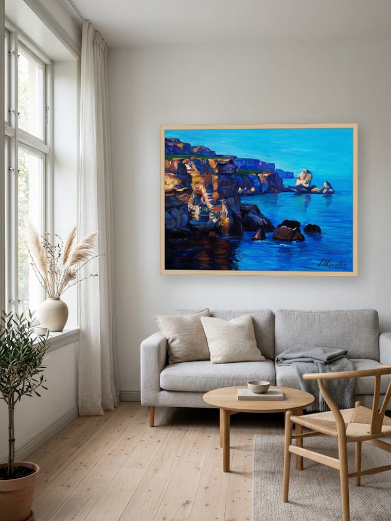Blue seascape oil painting on a white wall above a pale linen sofa